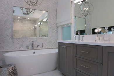 Inspiration for a mid-sized contemporary master bathroom with shaker cabinets, medium wood cabinets, a freestanding tub, an alcove shower, white tile, marble, white walls, marble floors, an undermount sink, engineered quartz benchtops, white floor, a hinged shower door and white benchtops.
