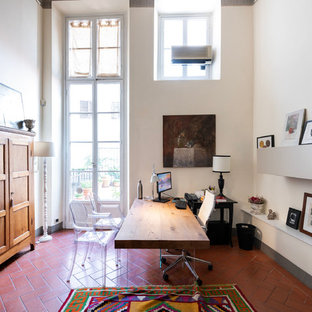 Photo of a large modern study in Florence with white walls, terracotta flooring, no fireplace, a freestanding desk and brown floors.