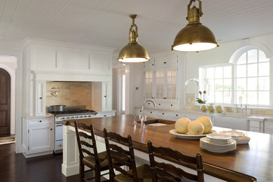 Elegant u-shaped enclosed kitchen photo in Los Angeles with a farmhouse sink, beaded inset cabinets, white cabinets, wood countertops, beige backsplash, stone slab backsplash and stainless steel appliances