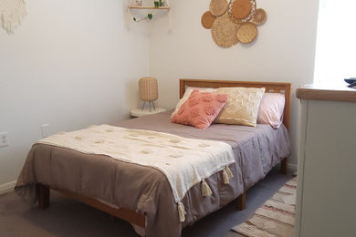 Example of a small eclectic guest carpeted and gray floor bedroom design in Austin with white walls and no fireplace