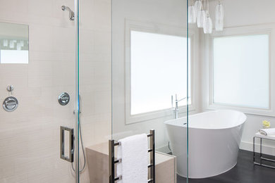 This is an example of a mid-sized modern master bathroom in Los Angeles with flat-panel cabinets, medium wood cabinets, a freestanding tub, a curbless shower, beige tile, ceramic tile, white walls, ceramic floors, a drop-in sink, limestone benchtops, grey floor, a hinged shower door and beige benchtops.