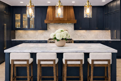 Inspiration for a mid-sized transitional u-shaped medium tone wood floor and brown floor eat-in kitchen remodel in Minneapolis with an undermount sink, shaker cabinets, blue cabinets, quartz countertops, white backsplash, marble backsplash, stainless steel appliances, an island and white countertops