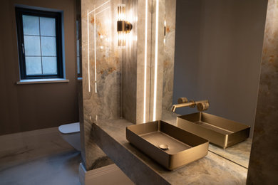 Foto på ett funkis flerfärgad en-suite badrum, med en vägghängd toalettstol, flerfärgad kakel, porslinskakel, flerfärgade väggar, klinkergolv i porslin, ett piedestal handfat, kaklad bänkskiva och vitt golv