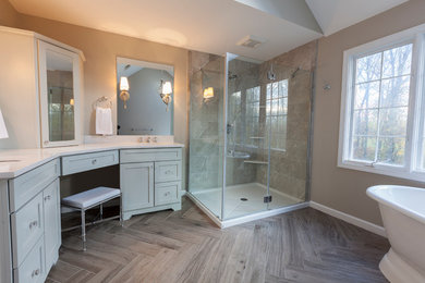 Inspiration for a mid-sized transitional master gray tile and porcelain tile porcelain tile and gray floor bathroom remodel in New York with flat-panel cabinets, gray cabinets, a two-piece toilet, gray walls, an undermount sink, quartz countertops and a hinged shower door