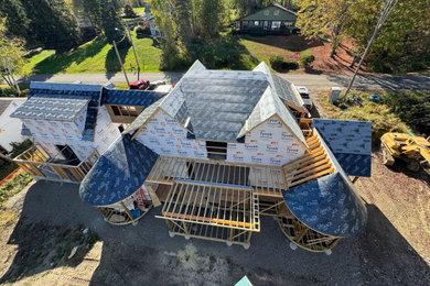Inspiration for a mid-sized beige two-story wood and shingle exterior home remodel in New York with a shingle roof and a brown roof
