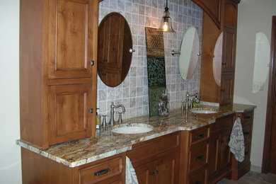 Example of a large mountain style master beige tile and porcelain tile ceramic tile bathroom design in Cleveland with a drop-in sink, furniture-like cabinets, medium tone wood cabinets and granite countertops