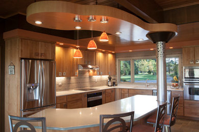 This is an example of a mid-sized modern u-shaped eat-in kitchen in Orange County with an undermount sink, flat-panel cabinets, medium wood cabinets, laminate benchtops, white splashback, matchstick tile splashback, stainless steel appliances, ceramic floors and with island.