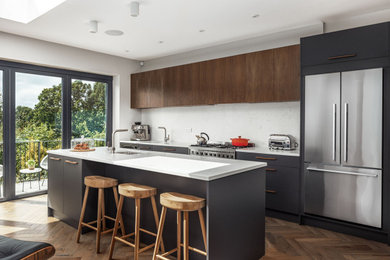 Medium sized modern open plan kitchen in London with a built-in sink, flat-panel cabinets, medium wood cabinets, quartz worktops, white splashback, an island and white worktops.