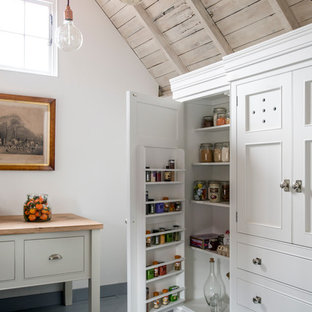 Country kitchen pantry in Sussex with beaded inset cabinets, white cabinets and painted wood floors.