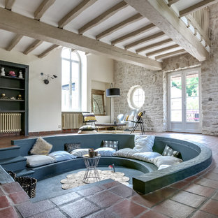 Ispirazione per un soggiorno mediterraneo di medie dimensioni e aperto con pavimento in terracotta, pareti beige e pavimento rosso