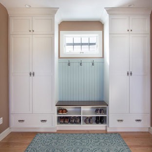 Immagine di un piccolo ingresso con anticamera tradizionale con pareti marroni, pavimento in legno massello medio, una porta bianca e pavimento blu