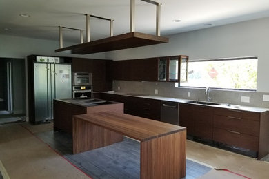 Example of a large minimalist light wood floor and gray floor eat-in kitchen design in Minneapolis with an undermount sink, flat-panel cabinets, dark wood cabinets, quartzite countertops, gray backsplash, porcelain backsplash, stainless steel appliances and two islands