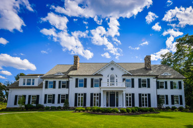 Example of a large classic white two-story concrete fiberboard exterior home design in New York with a tile roof