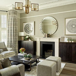 Idee per un piccolo soggiorno classico con sala formale, pavimento in legno massello medio, camino classico, cornice del camino in pietra, TV nascosta, pareti grigie e pavimento marrone