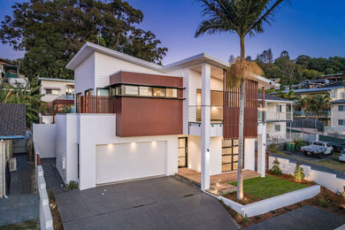 Inspiration for a large contemporary two-storey white house exterior in Gold Coast - Tweed with mixed siding, a flat roof and a metal roof.