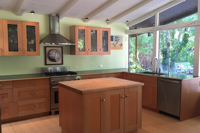 Inspiration for a mid-sized mid-century modern l-shaped bamboo floor eat-in kitchen remodel in San Francisco with a single-bowl sink, shaker cabinets, light wood cabinets, wood countertops, stainless steel appliances, an island and window backsplash