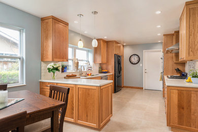 Eat-in kitchen - mid-sized transitional u-shaped ceramic tile and beige floor eat-in kitchen idea in San Francisco with a double-bowl sink, shaker cabinets, light wood cabinets, quartz countertops, white backsplash, subway tile backsplash, black appliances, a peninsula and white countertops