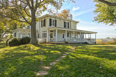 Large traditional white two-story wood exterior home idea in Other with a hip roof