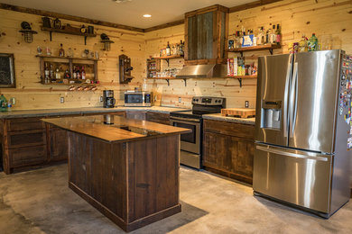 Inspiration for a small rustic u-shaped concrete floor and gray floor eat-in kitchen remodel in Wichita with a farmhouse sink, shaker cabinets, distressed cabinets, concrete countertops, brown backsplash, wood backsplash, stainless steel appliances and an island