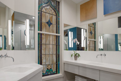 Example of a mid-sized trendy master white tile and ceramic tile slate floor, black floor, double-sink and vaulted ceiling bathroom design in Other with white cabinets, beige walls, an integrated sink, white countertops, a built-in vanity and flat-panel cabinets