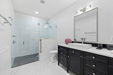 Bathroom - modern white tile and ceramic tile single-sink bathroom idea in Baltimore with black cabinets, a trough sink, quartz countertops and a hinged shower door