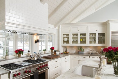 Example of a large trendy l-shaped eat-in kitchen design in Minneapolis with an undermount sink, recessed-panel cabinets, white cabinets, marble countertops, white backsplash, subway tile backsplash, stainless steel appliances and an island