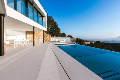 Foto de casa de la piscina y piscina infinita moderna grande rectangular en patio trasero