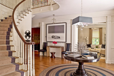 Inspiration for a mid-sized contemporary foyer in New York with white walls and medium hardwood floors.