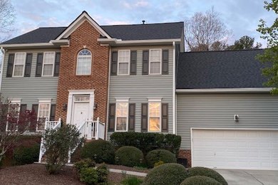 Elegant two-story vinyl house exterior photo in Raleigh with a shingle roof and a black roof