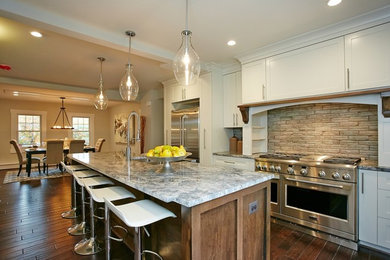 Open concept kitchen - large contemporary l-shaped dark wood floor open concept kitchen idea in DC Metro with a double-bowl sink, shaker cabinets, white cabinets, granite countertops, beige backsplash, stone slab backsplash, stainless steel appliances and an island