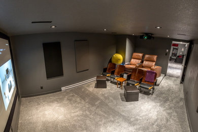 Design ideas for a mid-sized traditional enclosed home theatre in Calgary with grey walls, carpet, a projector screen and grey floor.