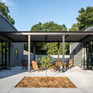 Design ideas for an industrial side yard patio in Houston with concrete slab.