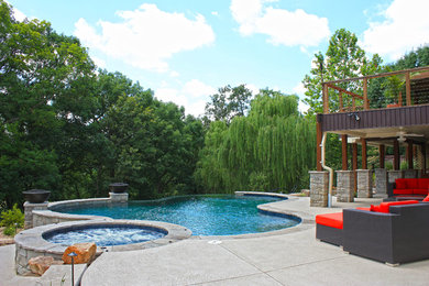 Hot tub - large traditional backyard concrete and custom-shaped infinity hot tub idea in St Louis