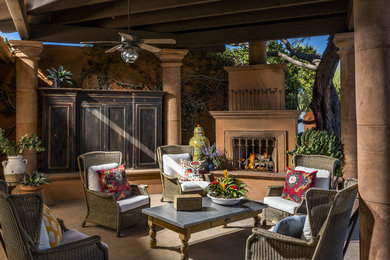 Inspiration for a mid-sized southwestern backyard brick patio remodel in Phoenix with a fire pit and a roof extension