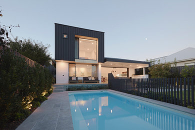Immagine di una grande piscina monocorsia minimalista rettangolare dietro casa con piastrelle