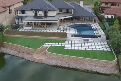 Inspiration for a huge modern backyard custom-shaped infinity hot tub remodel in Oklahoma City