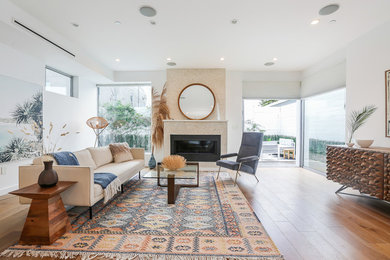 Living room - large modern open concept light wood floor and brown floor living room idea in Los Angeles with white walls, a standard fireplace, a tile fireplace and no tv