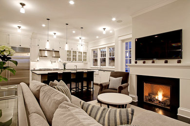 This is an example of a large traditional open concept living room in Seattle with white walls, a standard fireplace, a wall-mounted tv and dark hardwood floors.