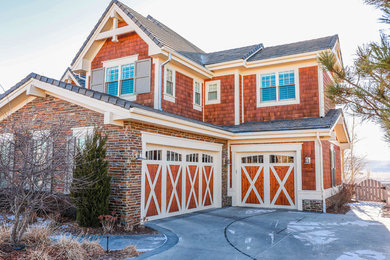Example of a large farmhouse attached three-car garage design in Denver