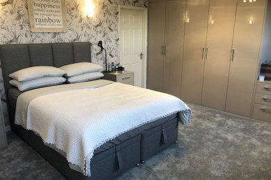 Imagen de dormitorio principal actual grande con paredes blancas, moqueta, suelo gris y papel pintado