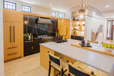 Eat-in kitchen - mid-sized contemporary single-wall eat-in kitchen idea in Denver with an undermount sink, flat-panel cabinets, light wood cabinets, quartz countertops, black backsplash, quartz backsplash, paneled appliances, an island and gray countertops