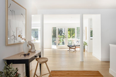 Inspiration for a large scandinavian light wood floor and brown floor foyer remodel in Vancouver with white walls