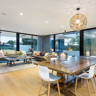 Photo of a large contemporary open plan dining in Melbourne with white walls, medium hardwood floors and brown floor.