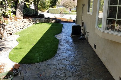 Photo of a mid-sized traditional side yard shaded xeriscape in San Francisco with a retaining wall and natural stone pavers.