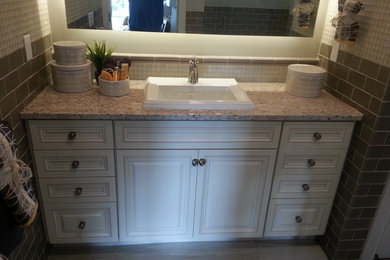 Mid-sized elegant kids' subway tile porcelain tile and gray floor alcove bathtub photo in Detroit with raised-panel cabinets, white cabinets, a two-piece toilet, a drop-in sink and granite countertops