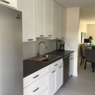 Cette photo montre une petite arrière-cuisine parallèle tendance avec un évier 2 bacs, un placard à porte shaker, des portes de placard blanches, un plan de travail en stratifié, une crédence rouge, une crédence en carreau de porcelaine, un électroménager en acier inoxydable et un sol en carrelage de porcelaine.