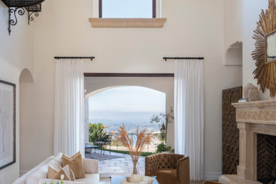 Tuscan travertine floor living room photo in San Diego with white walls and a stone fireplace