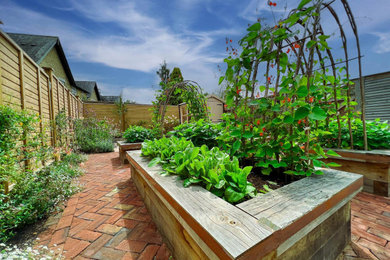 Modelo de jardín tradicional de tamaño medio en verano en patio con jardín francés, macetero elevado, exposición total al sol y con madera