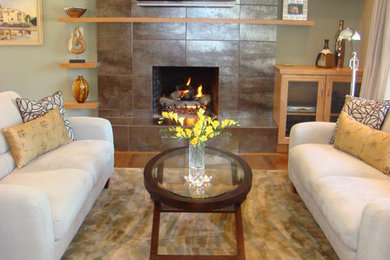 Transitional open concept light wood floor living room photo in Vancouver with green walls, a standard fireplace, a tile fireplace and a wall-mounted tv