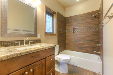 Mid-sized arts and crafts bathroom photo in Phoenix with raised-panel cabinets, medium tone wood cabinets, beige walls, an undermount sink and granite countertops